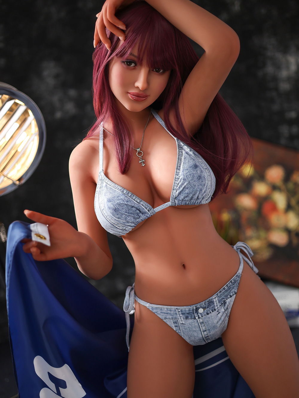 Alaya in an acid-wash denim bikini, one hand lifted to her wine red hair, waist measured at 20.9 inches