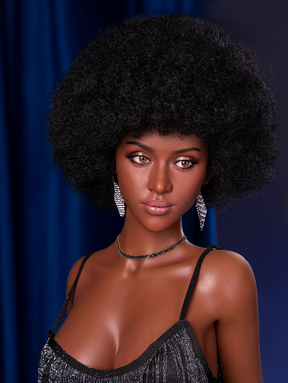 Celia close on the face, a round black afro over hazel eyes and warm brown silicone skin