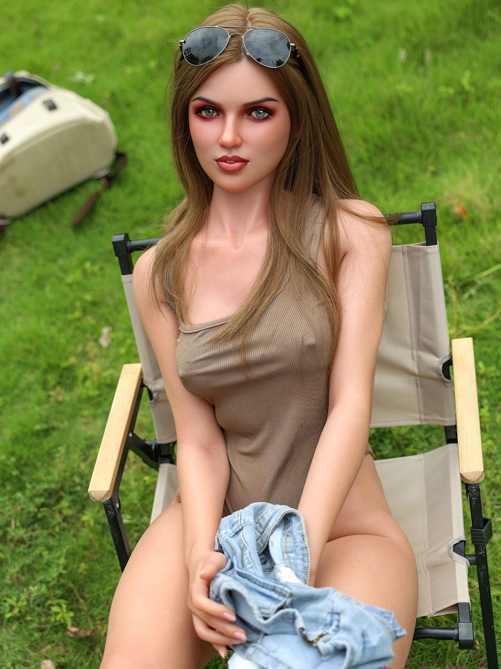 Clara seated with the denim shorts bunched between her thighs, gripped by the side in one hand